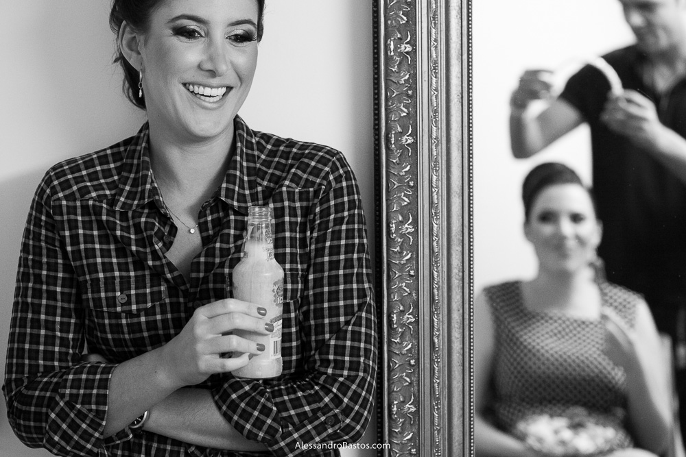 amiga da noiva sorri vendo ela se arrumar nas fotos do casamento em bh na igreja nossa senhora rainha em belo horizonte e a festa para fotografia dos noivos no jardim canada eventos para o fotografo e ela vai colocar a coroa de pérolas
