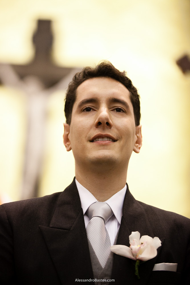 atentamente o noivo olha a noiva entrar nas fotos do casamento em bh na igreja nossa senhora rainha em belo horizonte e a festa para fotografia dos noivos no jardim canada eventos para o fotografo e ele bem sério