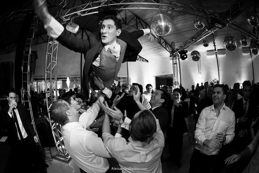 voando está o noivo nas fotos do casamento em bh no jardim canada eventos em belo horizonte e a festa para fotografia dos noivos no jardim canada eventos para o fotografo e os amigos jogam ele para o alto