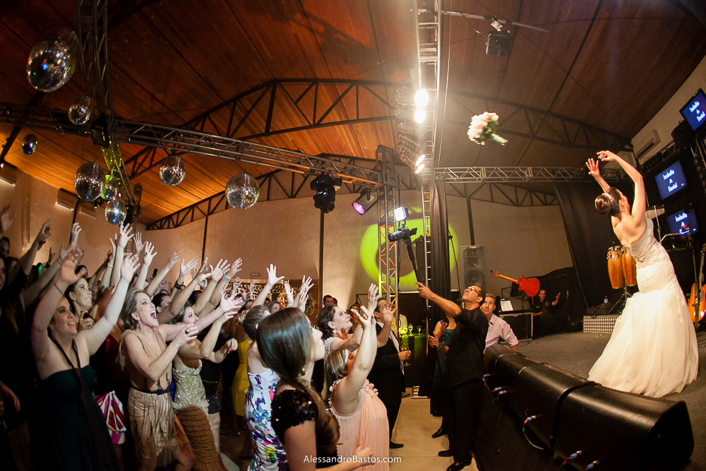 hora de jogar o buquê nas fotos do casamento em bh no jardim canada eventos em belo horizonte e a festa para fotografia dos noivos no jardim canada eventos para o fotografo e as mãos para o alto das solteiras