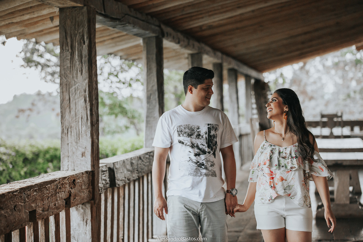 de mãos dados caminhando os noivos estão em foto pré-wedding para casamento em bh sendo feitas na fazenda solar do engenho em um dia nublado