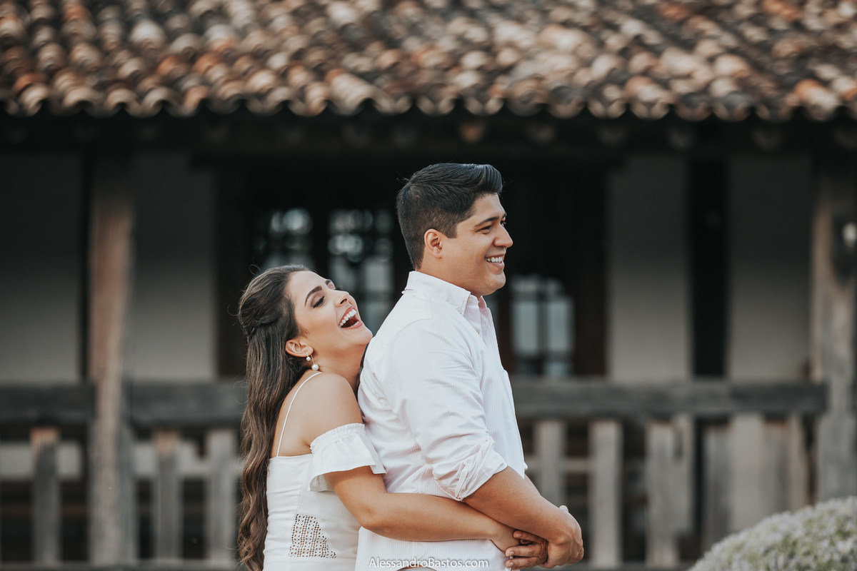 abraça por trás o noivo e sorri muito a noiva no solar do engenho durante a  sessão de fotos pré-wedding para casamento em bh no final de 2019