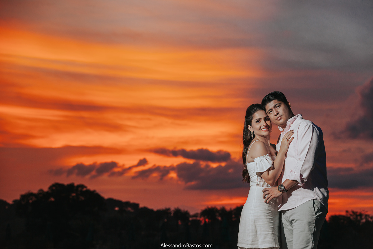 por-do-sol maravilhoso que surgiu durante as fotos pré-wedding no solar do engenho depois de um dia nublado para casamento em bh e os noivos olhando para a câmera em um retrato
