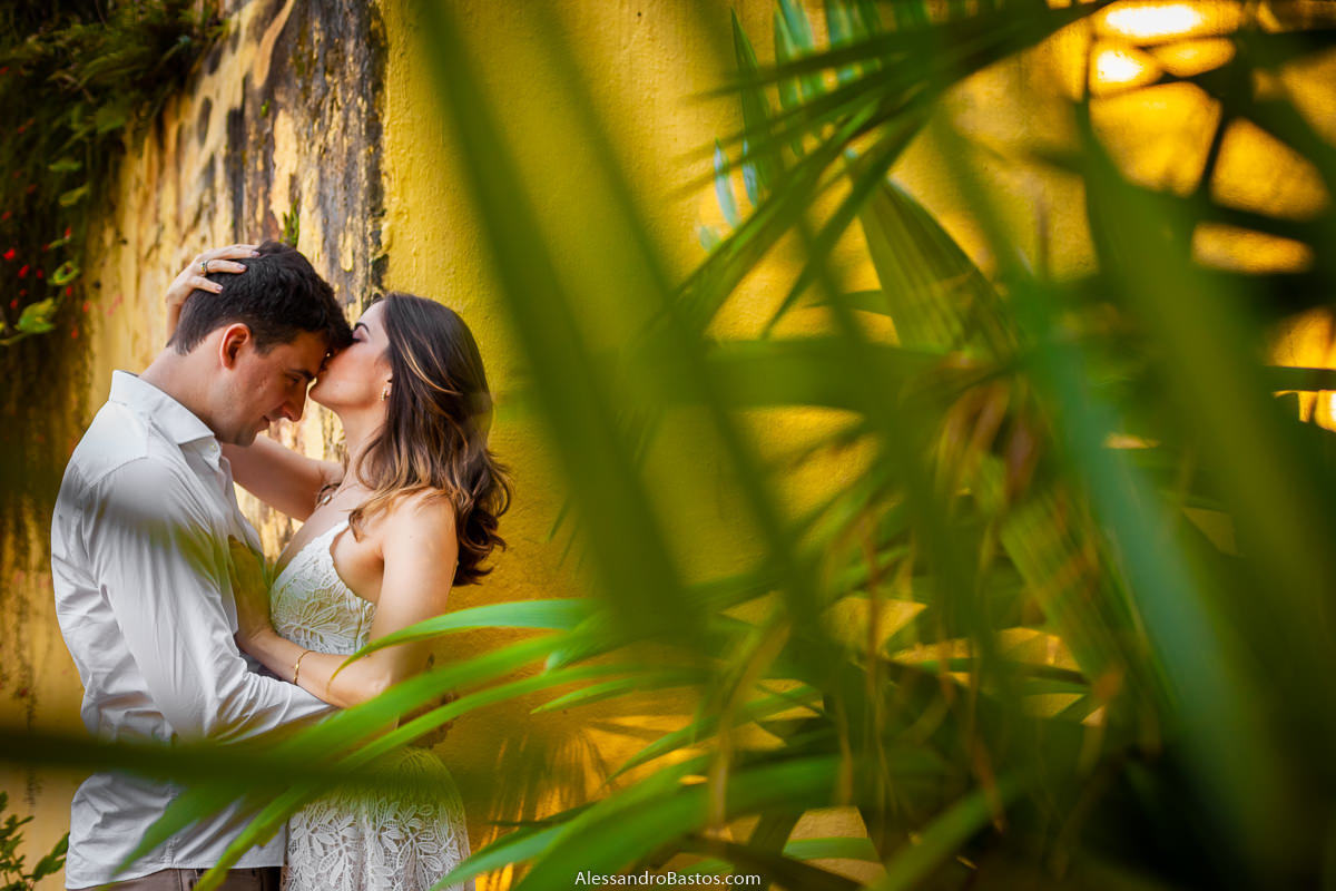 beijo na testa do noivo nas fotos de noivos para casamento em bh fotografo com o fundo amarelo