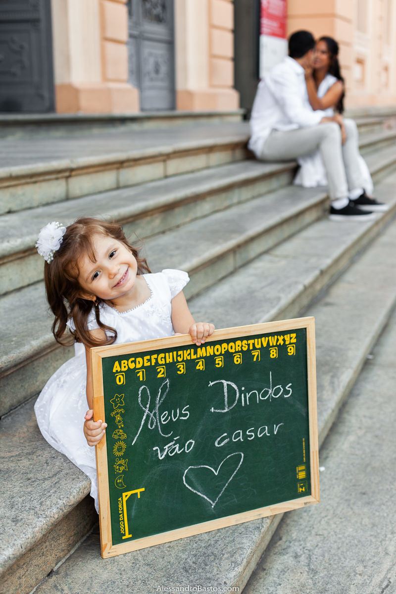 plaquinha na mão da daminha nas fotos para o fotografo de noivos para casamento em belo horizonte e ela fazendo uma pose bem fofinha