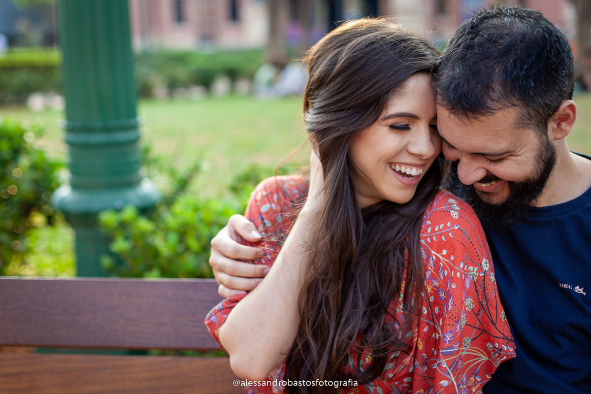 juntinhos os noivos estão nas fotos e fotografo de noivos em belo horizonte para casamento no pré-wedding e pré-casamento e sentados em um banco da praça da liberdade