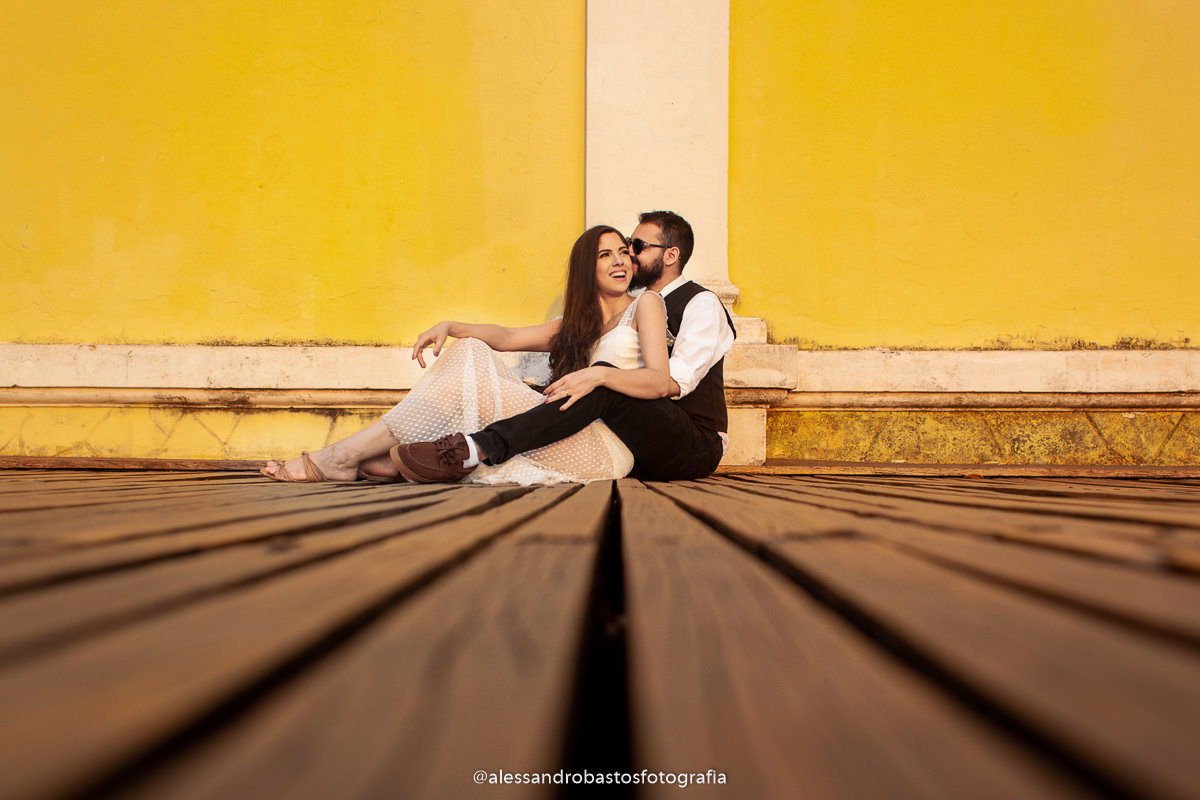 sentados nas fotos e fotografo de noivos em belo horizonte para casamento no pré-wedding e pré-casamento e umas ripas de madeira servem de chão