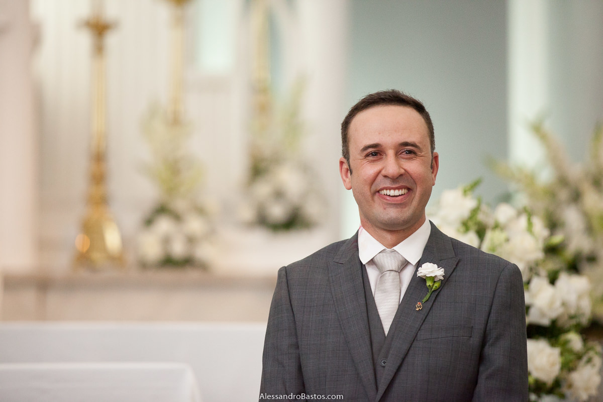 sorridente o noivo vê a noiva entrar nas fotos fotografo do casamento dos noivos em bh belo horizonte e o altar ao fundo