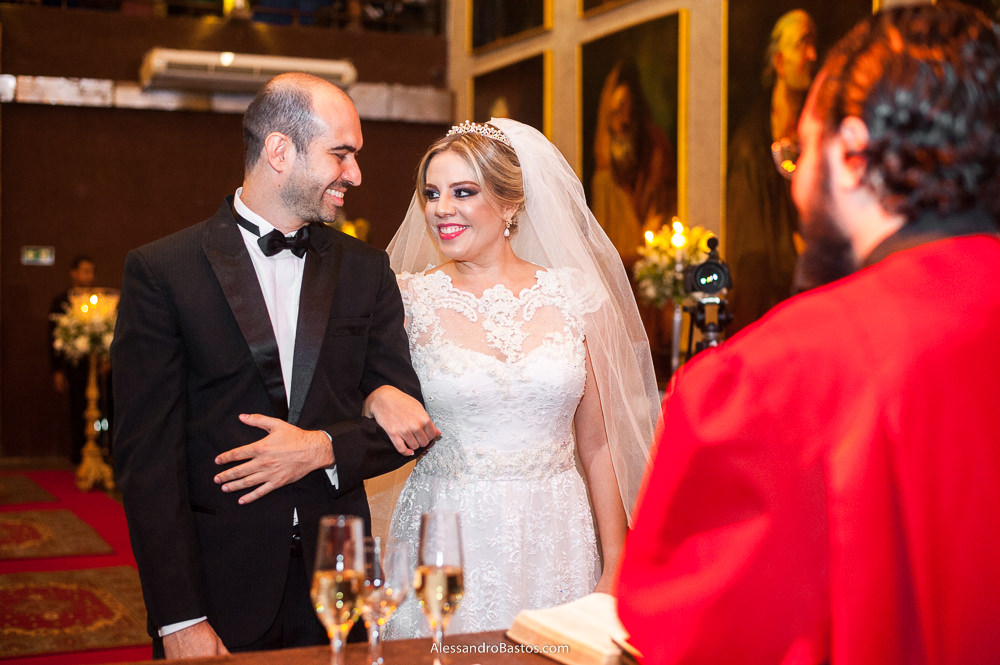 olhos dos noivos se cruzam no altar durante a cerimônia do casamento deles no caravaggio bh e eles sorriem muito um para o outro