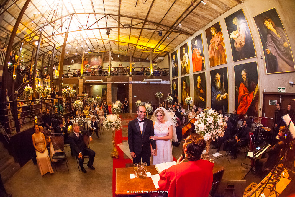 sorridentes estavam os noivos no altar do casamento deles que foi relizado no caravaggio em bh num dia lindo de verão