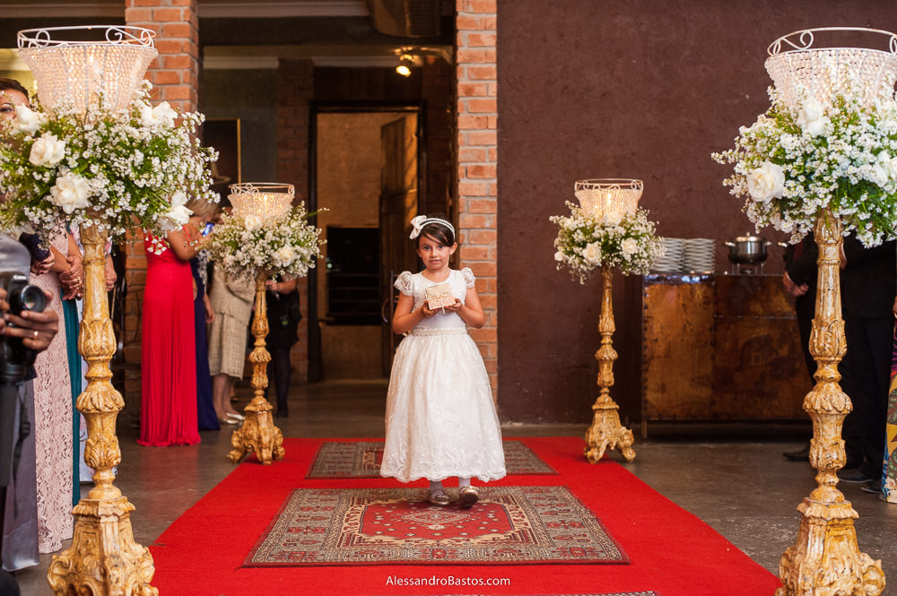 a dama de hora entra na cerimônia do casamento do Gu levate no caravaggio em nova lima segurando as alianças