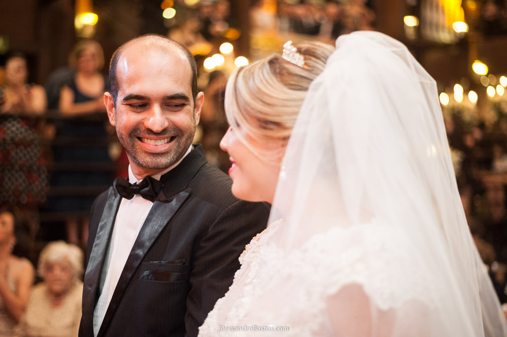 troca de olhares dos noivos durante a cerimônia do casamento no caravaggio bh onde se olham e sorriem