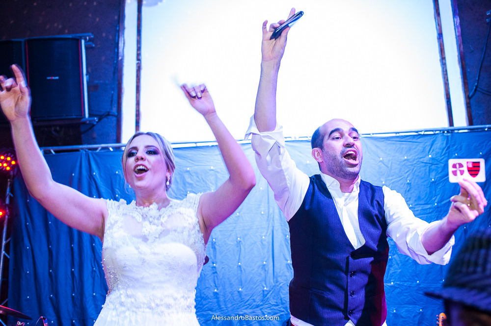 com os braços pra cima e no palco da banda do casamento bh no caravaggio os noivos demonstram que estavam muito felizes com a festa