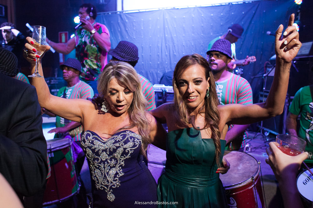 madrinha no casamento da camila levate no caravaggio bh dançam com a banda do mestre linguinha ao fundo da foto em tom magenta