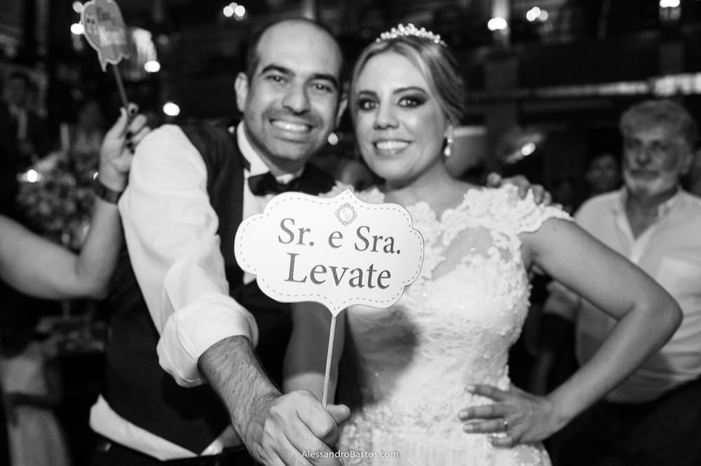 noivos em seu casamento em belo horizonte no caravaggio seguram uma placa escrito o nome deles como senhor e senhora