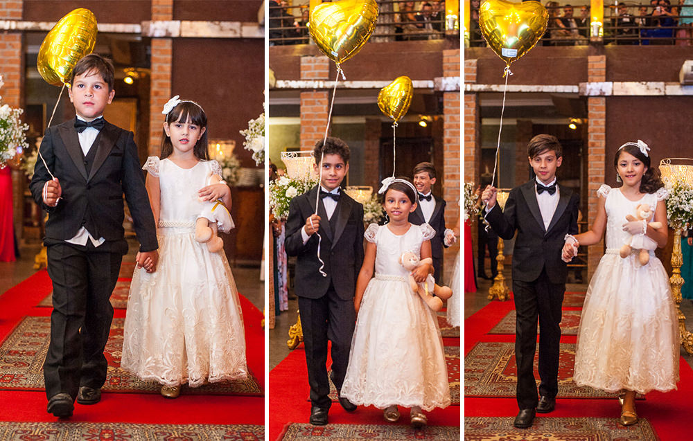 agora os três casais de pajens e damans entram na cerimônia do casamento no caravaggio em bh com balões dourados e as meninas segurando ursinhos de pelúcia