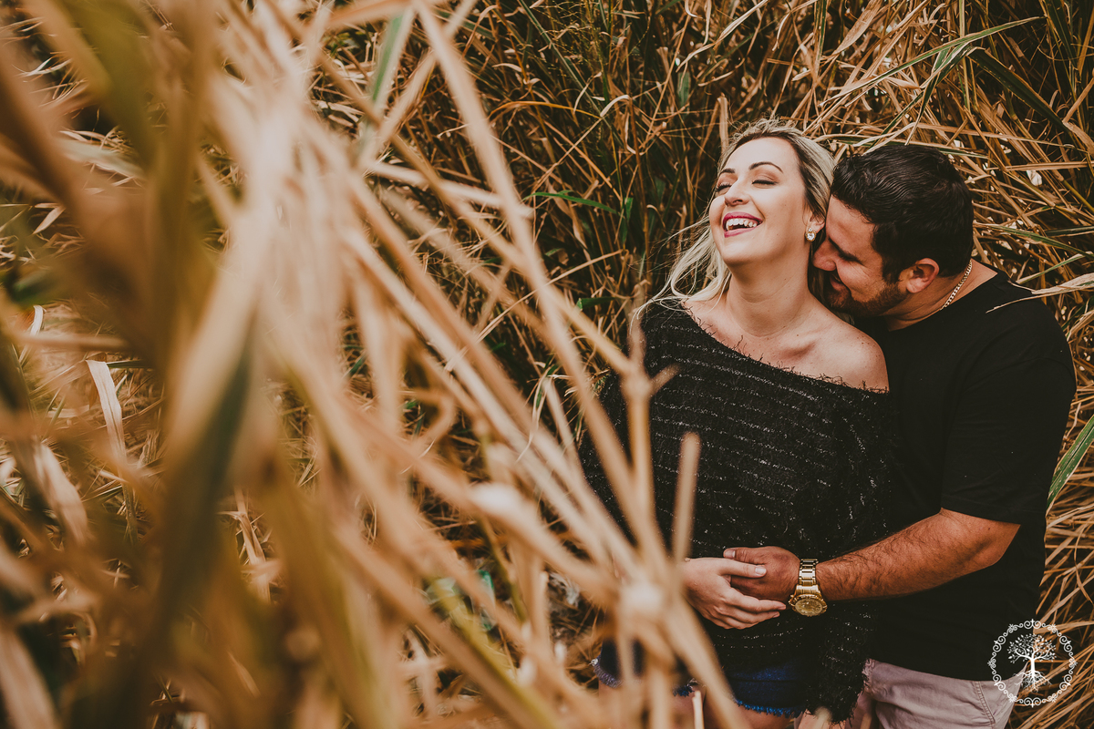 fotografo usa sua criatividade para captar momento expontaneo entre casal na praia em meio a vegetação