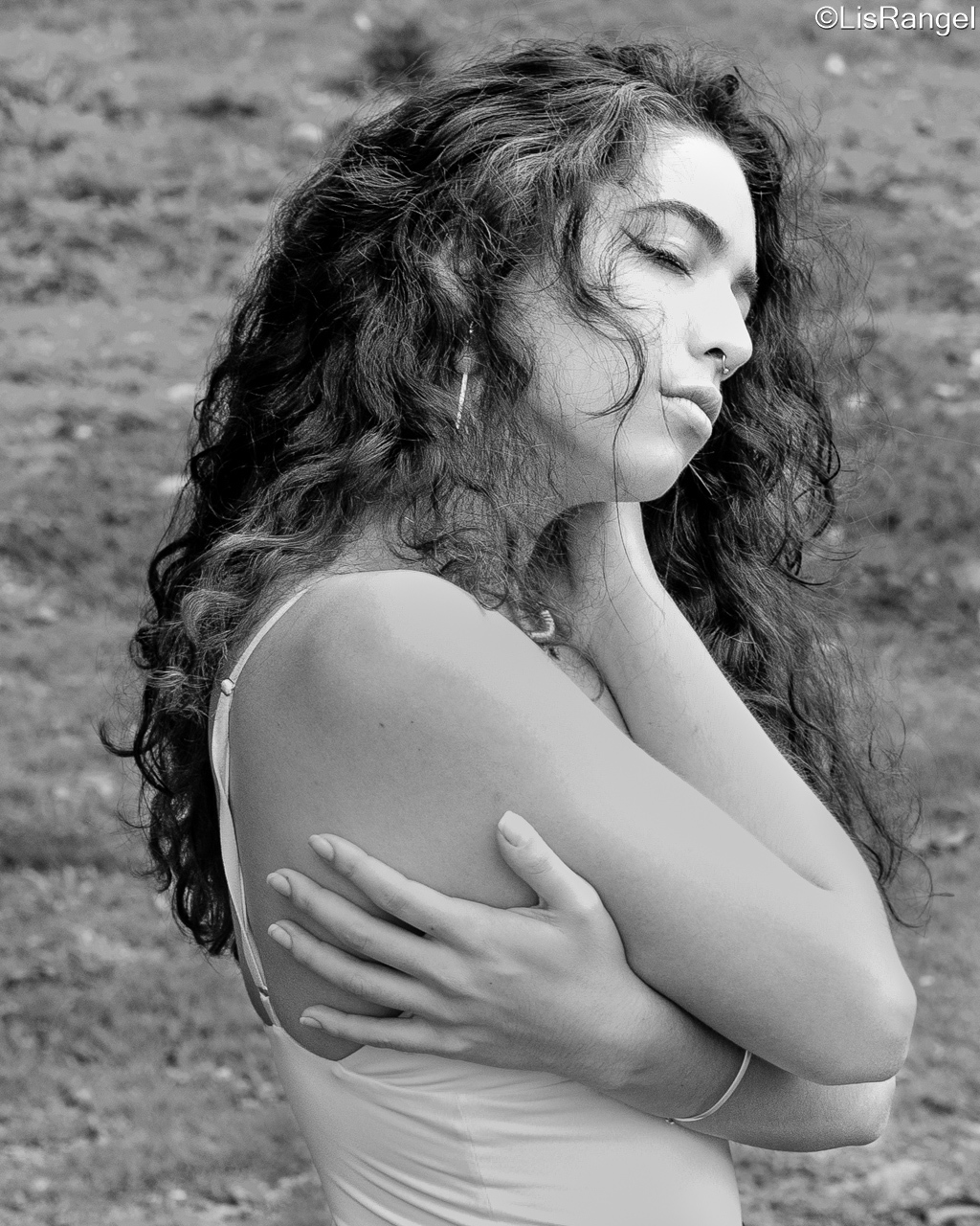 Mulher de lado abraçando o próprio corpo em sinal de amor próprio.