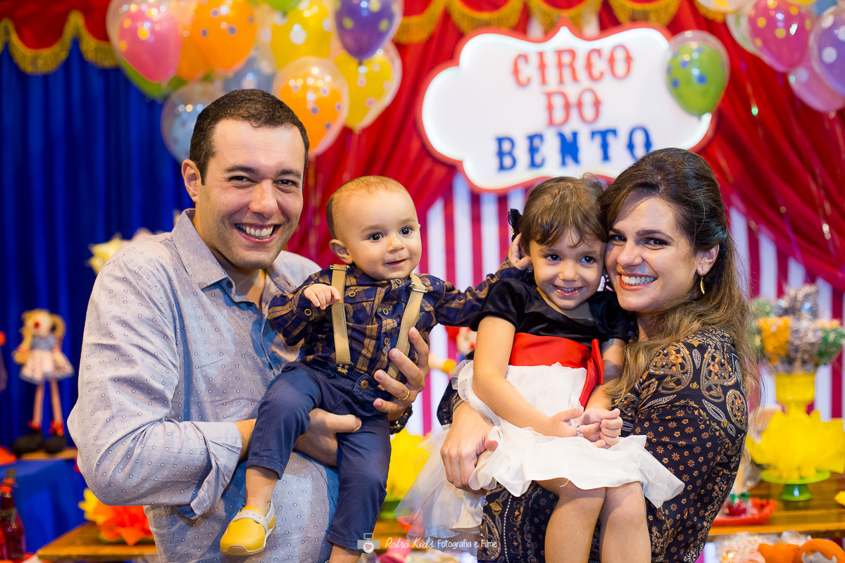 família em frente a mesa de decoração na festa infantil