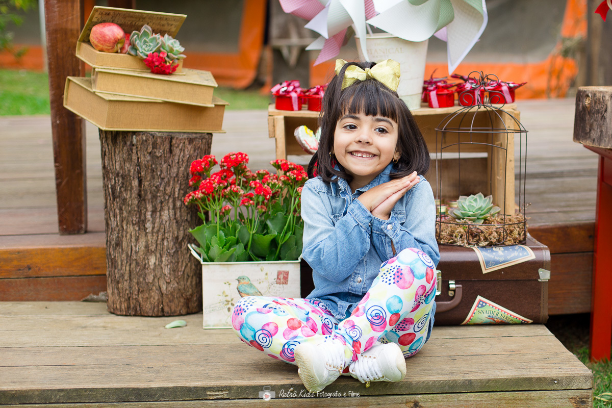 criança em frente a sua mesa decorada no sítio ao ar livre