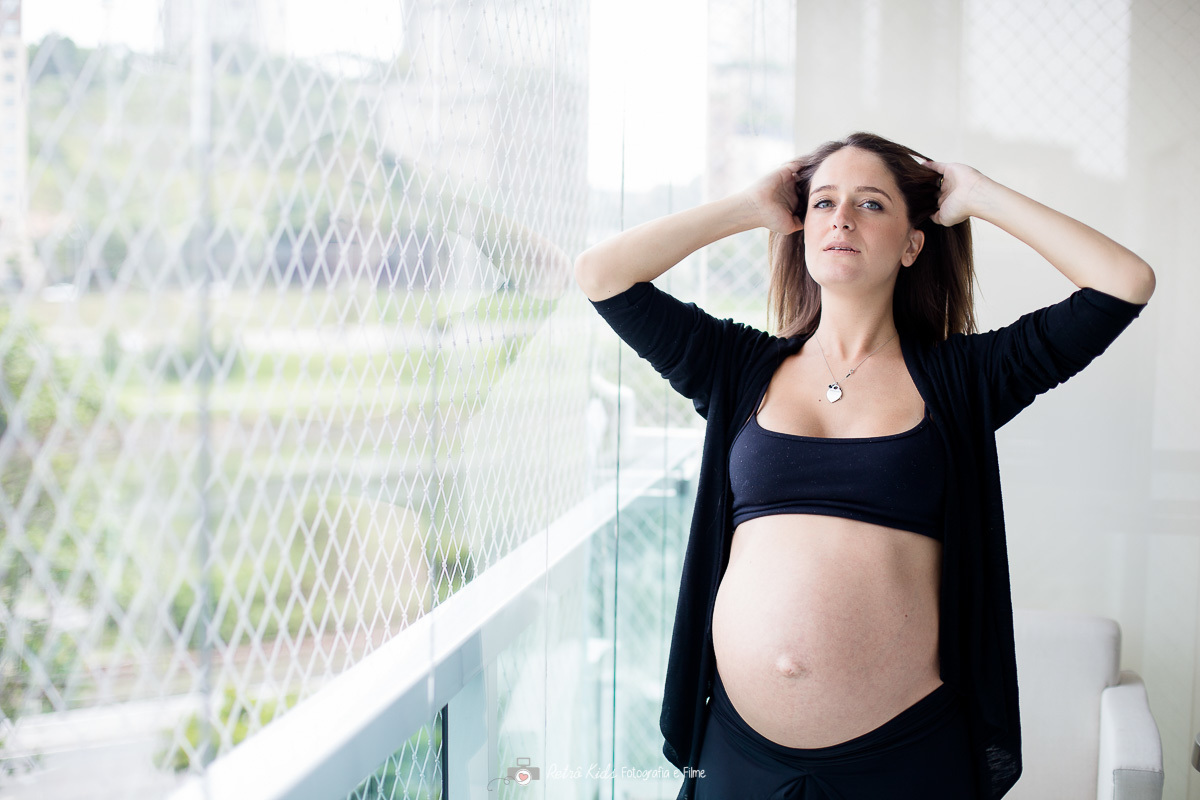 gestante na sacada do apartamento para sessão fotográfica