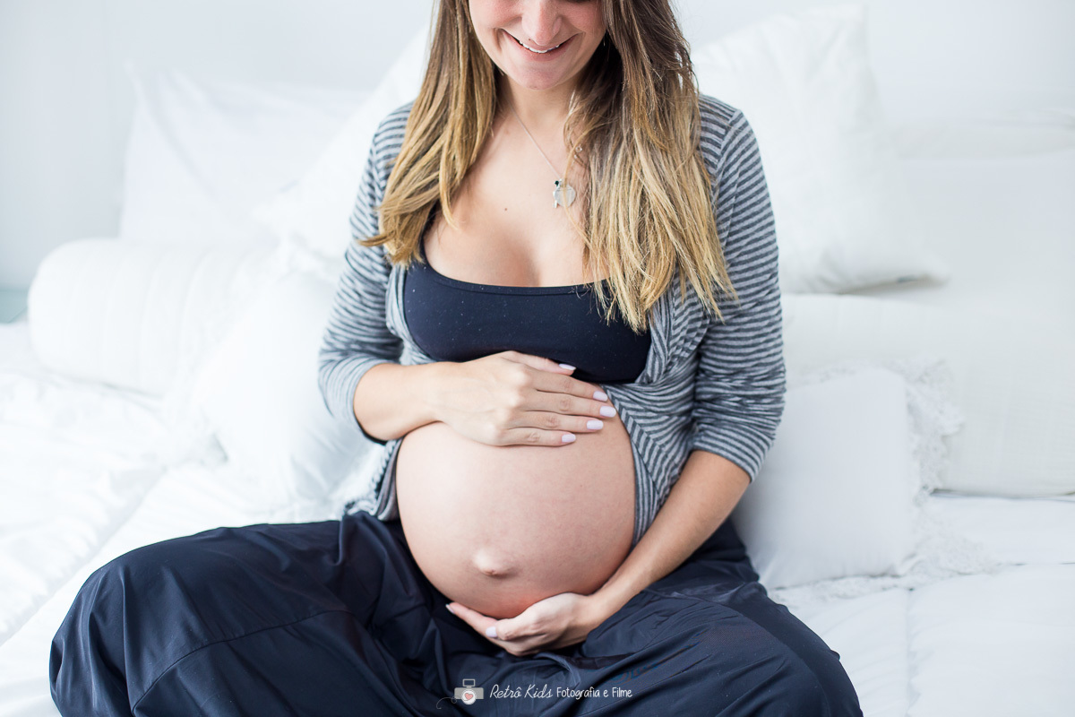 fotografia segurando a barriga dentro do apartamento em sp