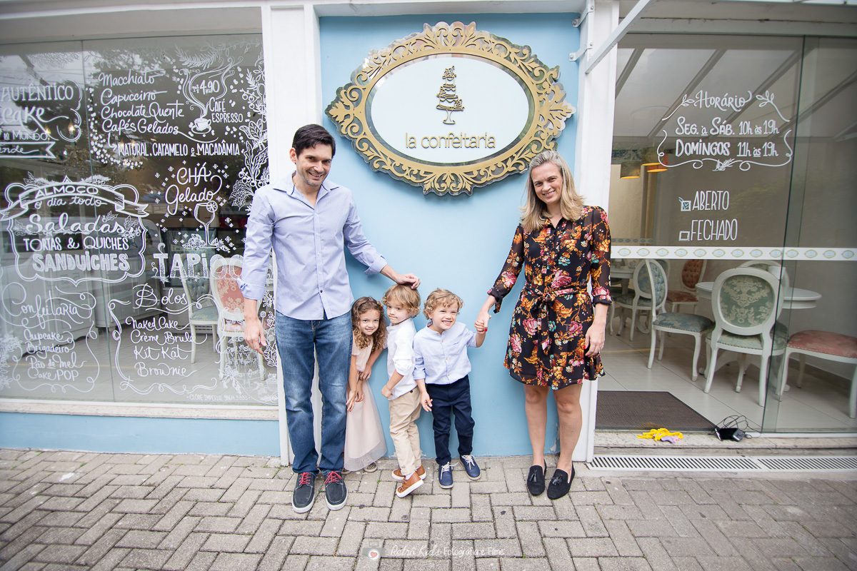 Fotogrfia da família na fachada da Cafeteira chamada la confeitaria na vila leopoldina em são paulo

