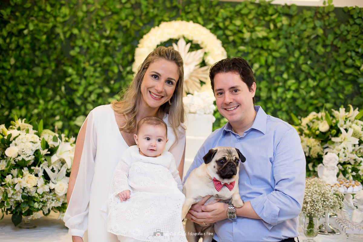 Família posa para fotografia na frente da mesa da recepção do batizado da Helena