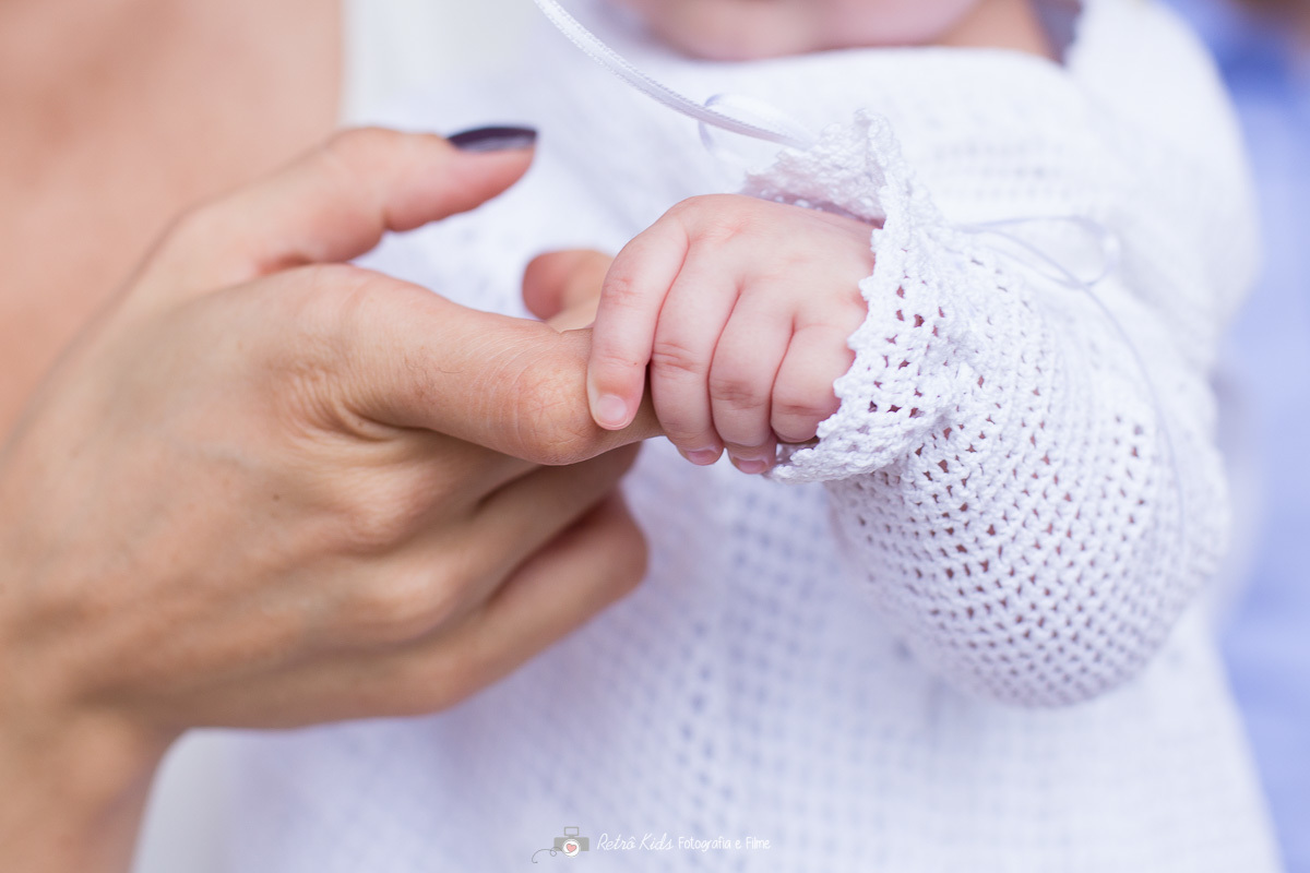 Detalhes do bebê segurando a mão da mãe no dia do seu batizado na catedral anglicana de são paulo