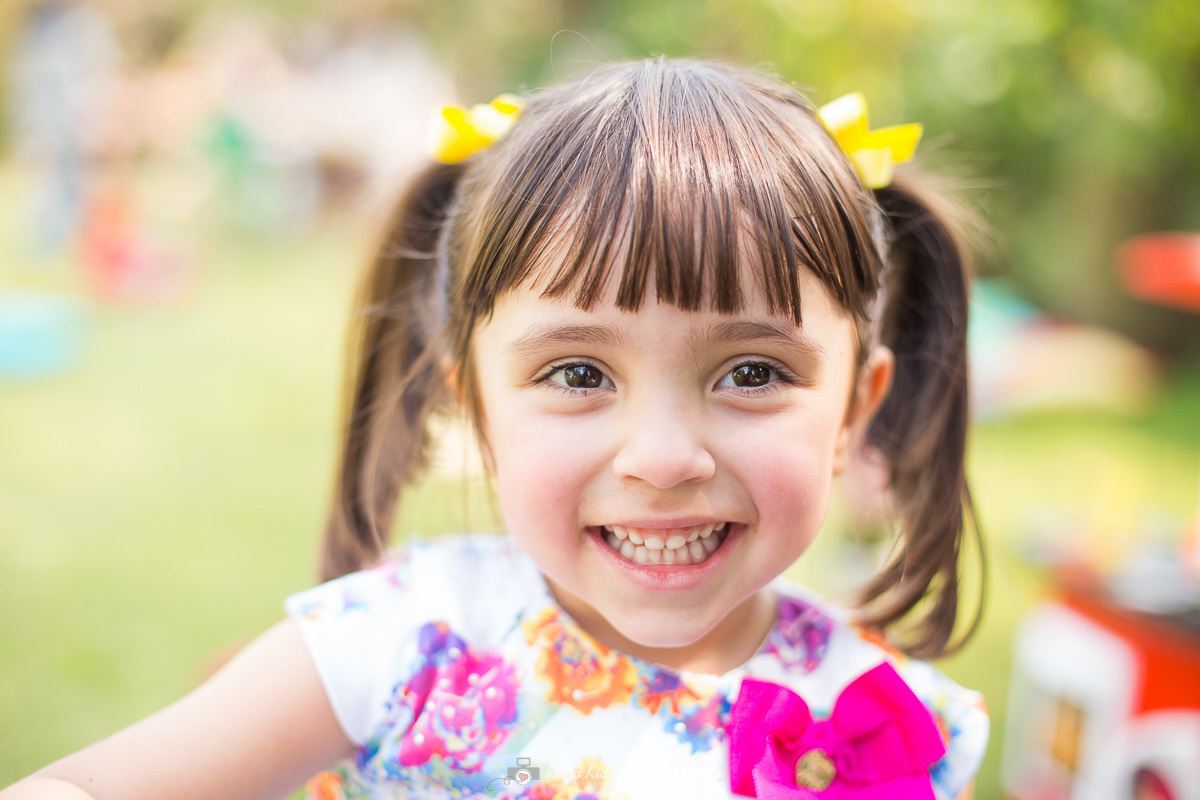 Foto da aniversariante muito feliz e sorridente com festa picnic ao ar livre para comemorar seu aniversário de 4 anos
