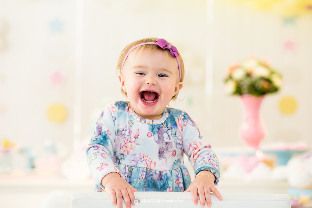aniversariante em frente a mesa decorada com sorriso banguelo
