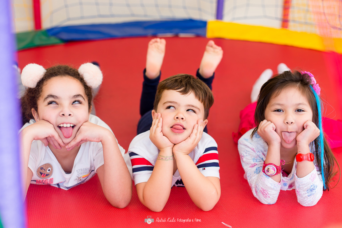 primos deitados de barriga para baixo no pula pula