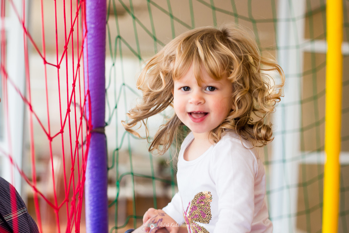 criança brincando no pula pula com cabelos ao vento em condomínio Tamboré SP