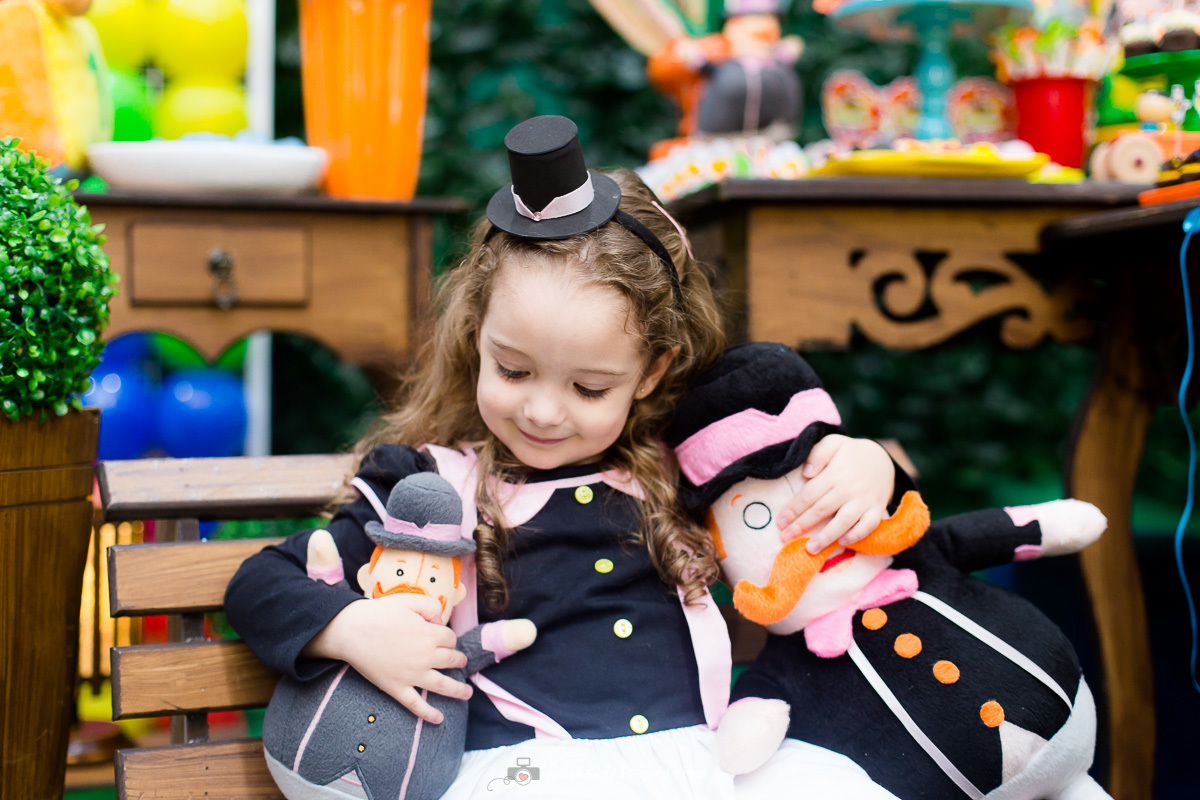 Catarina fantasiada e segurando personagens do mundo bita durante sua festa infantil