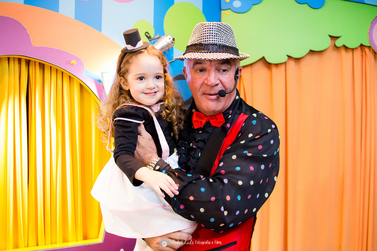 Catarina no colo do mágico em cima do palco do show no Buffet Vip Kids em São Paulo SP