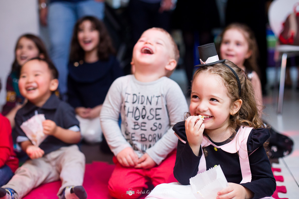 Crianças sorrindo durante apresentação de show de mágica