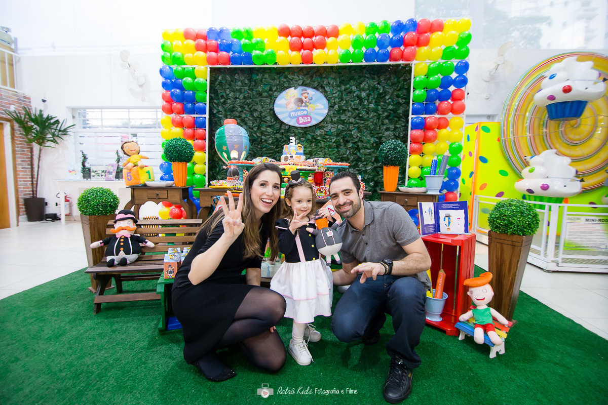 Família posando em frente a mesa para fotografia infantil no Buffet Vip Kids em São Paulo SP