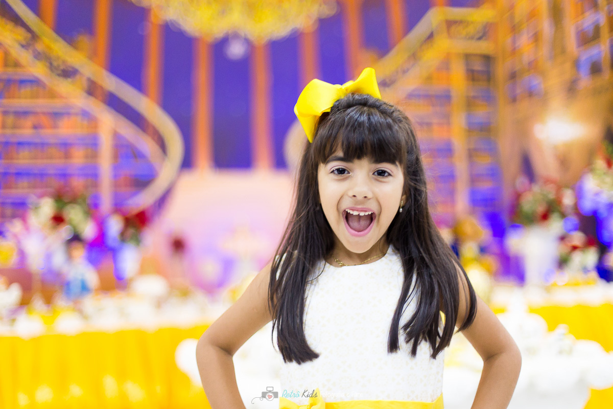 Manuella posando para fotografia em frente a sua mesa da Bela e a Fera