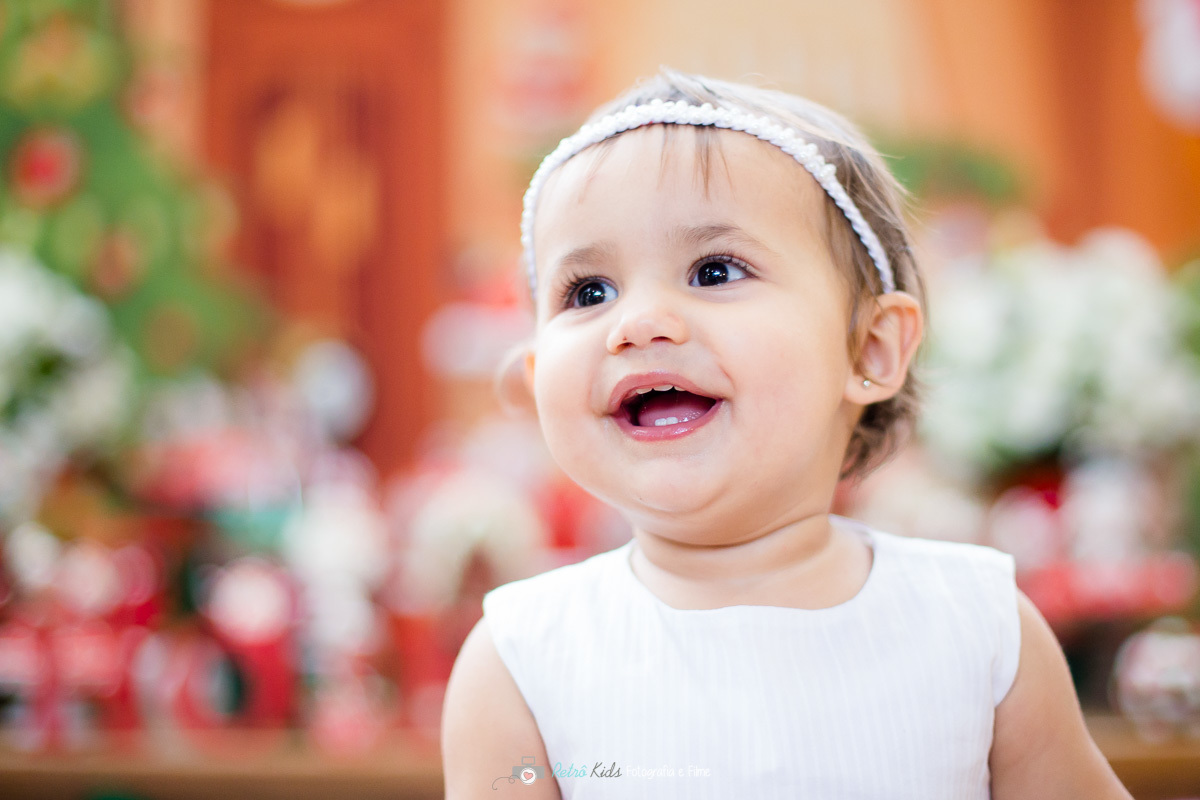 Alice posando para fotografia na sua decoração com o tema papai noel por Retrô Kids Fotografia