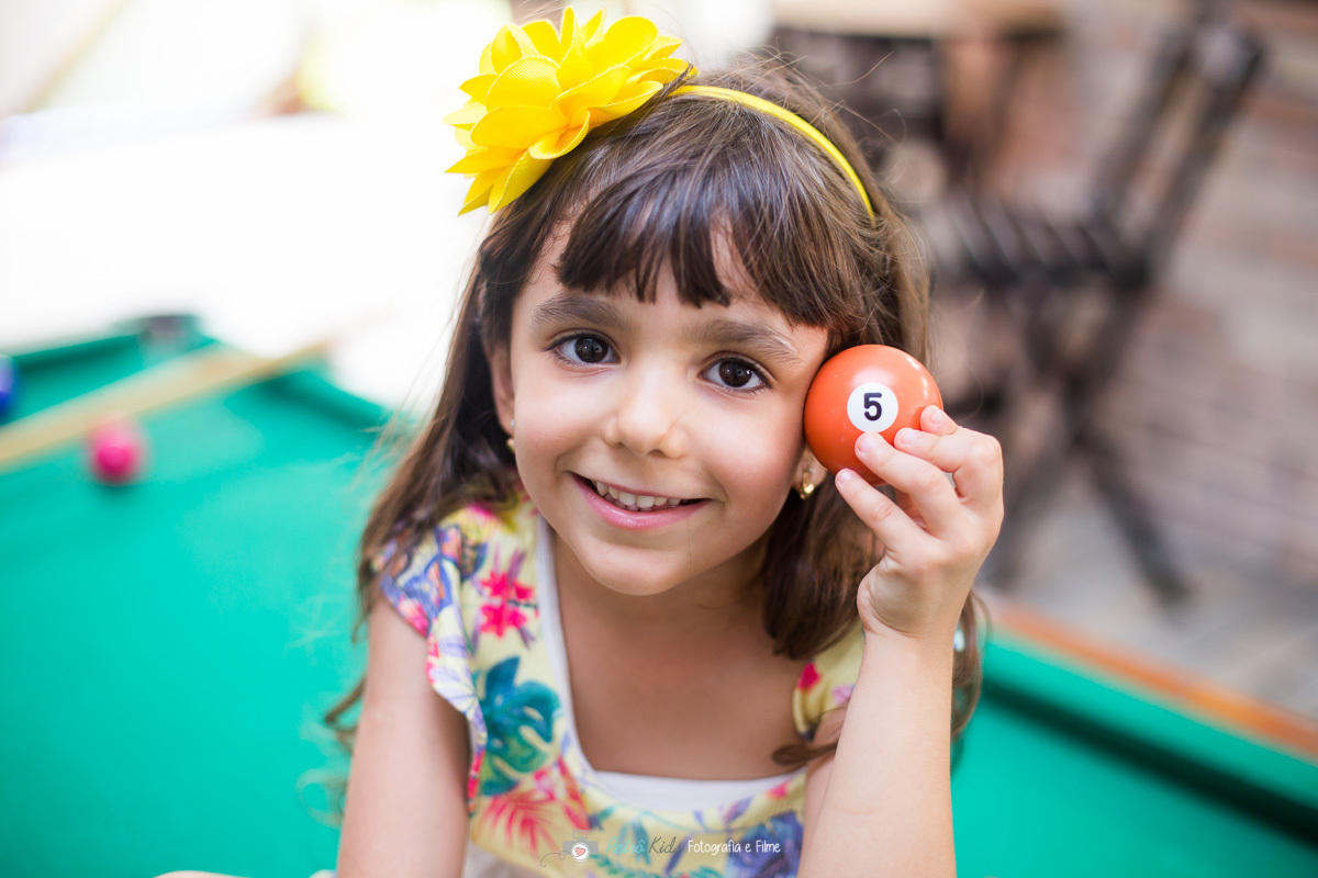 Laura brincando de bilhar durante sua festa de aniversário 