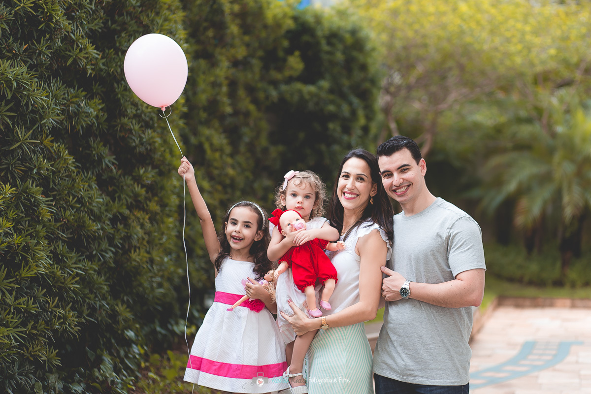 Fotografia da família na área externa do condomínio para comemorar o aniversário de 2 aninhos da Lívia