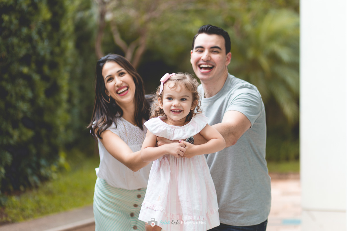 Retrato espontâneo dos pais junto com a aniversariante brincando de aviãzinho
