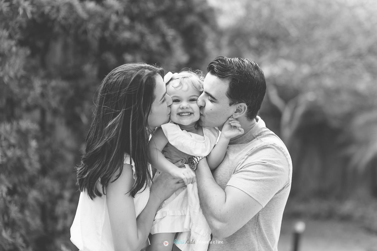 Retrato dos pais com a aniversariante dando um beijinho carinhoso