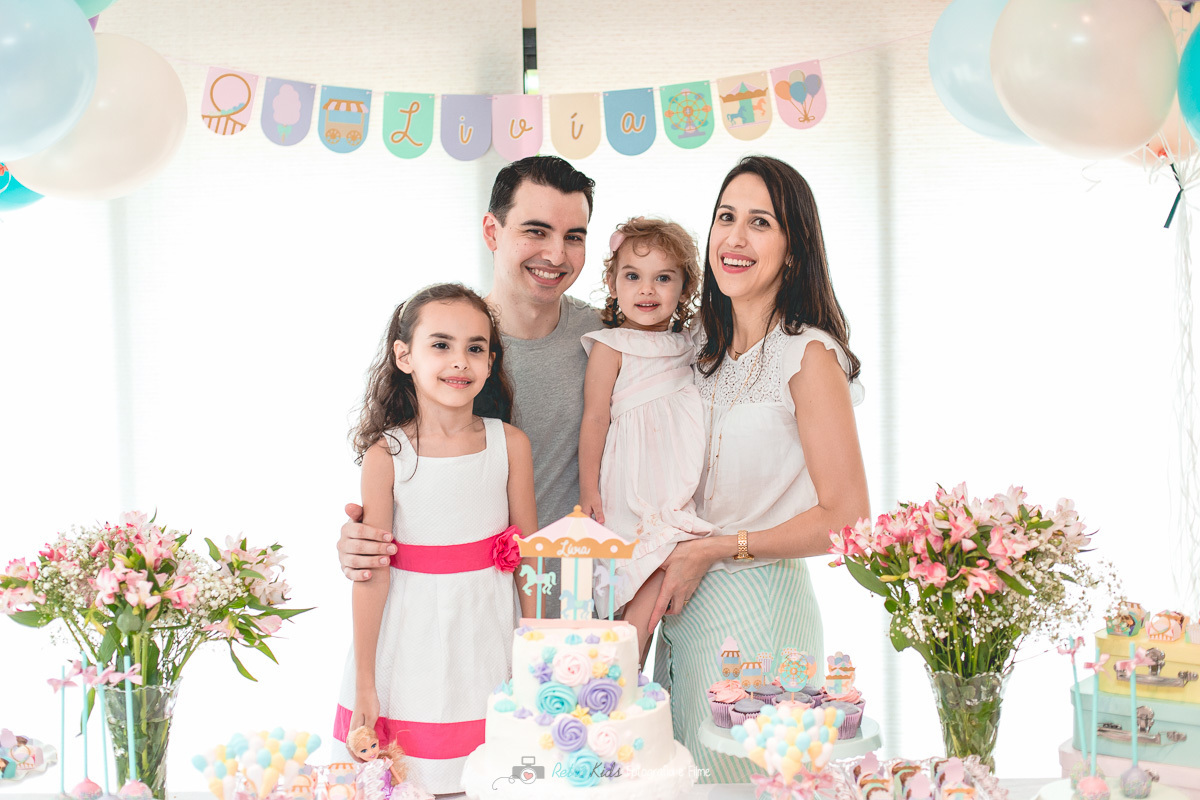 Fotografia da família na mesa decorada com o tema parque de diversões no Condomínio da família na Chácara Santo Antonio em SP