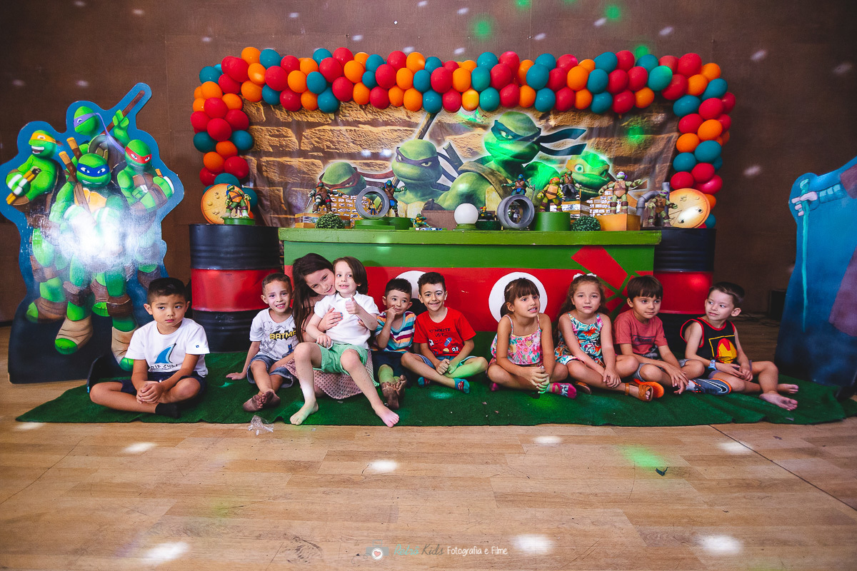 Retrato do Piettro com todos os seu amigos em frente sua mesa decorada da Tartaruga Ninja no Buffet Planeta Kids Tatuapé SP