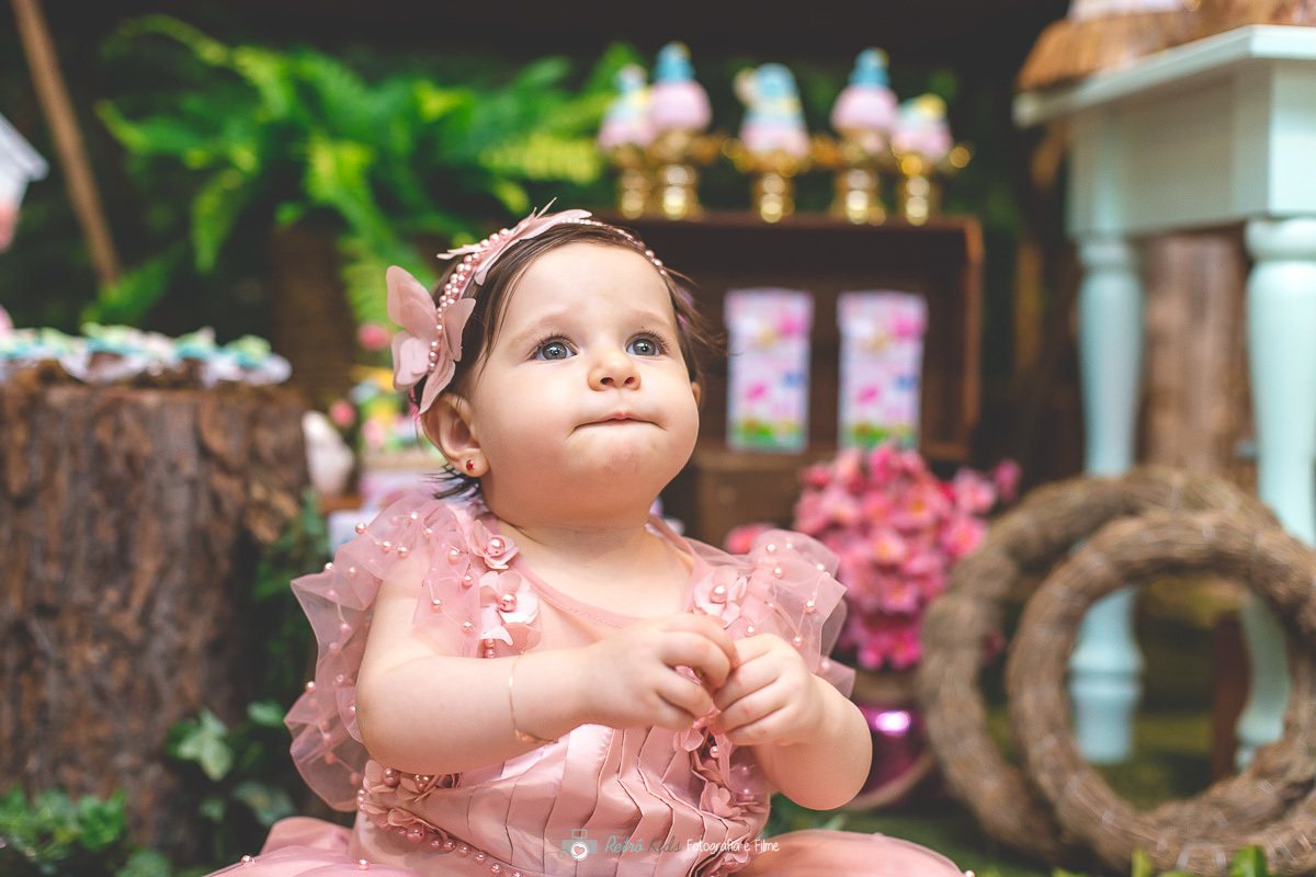 Aniversário de 1 aninho da Lara em frente sua mesa personalizada com o tema Jardim