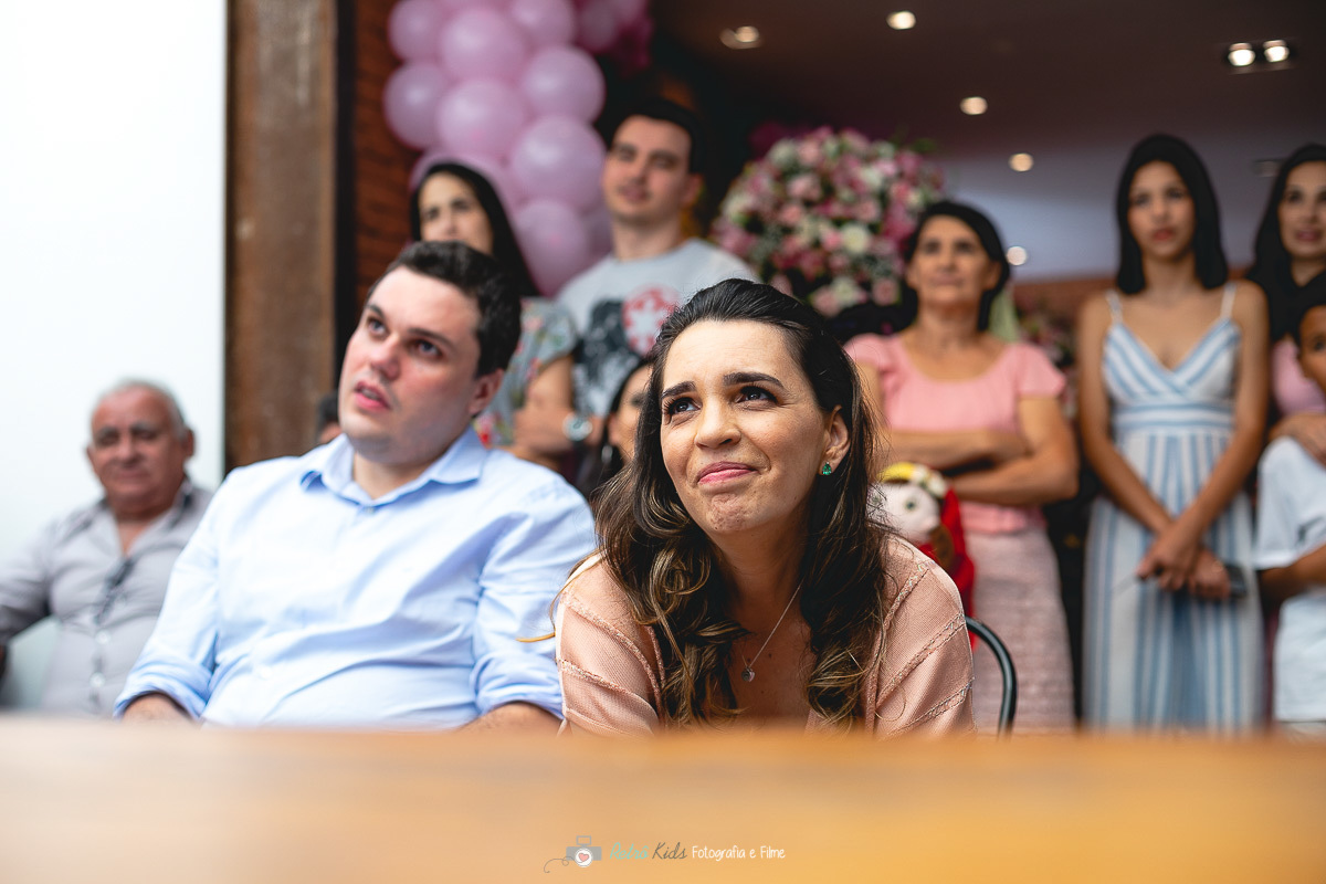 Pais emocionados assistindo a retrospectiva de depoimentos por Retrô Kids Fotografia