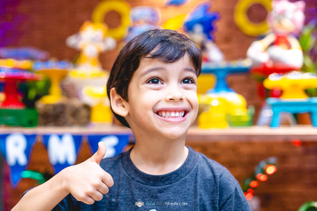 Gui se divertindo muito em frente sua mesa personalizada com seu tema favorito do Sonic para sua festa infantil de 5 anos