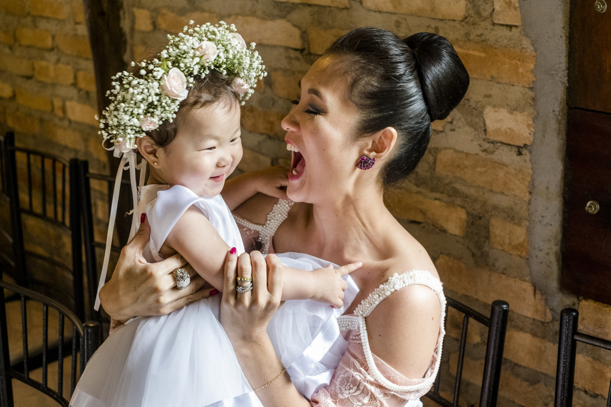 irmã do noivo curtindo a sobrinha antes da entrada dos noivos para a cerimonia do casamento que foi celebrada pelo Luciano Celebrante e realizada no salao de festas  que fica em mogi das cruzes sp