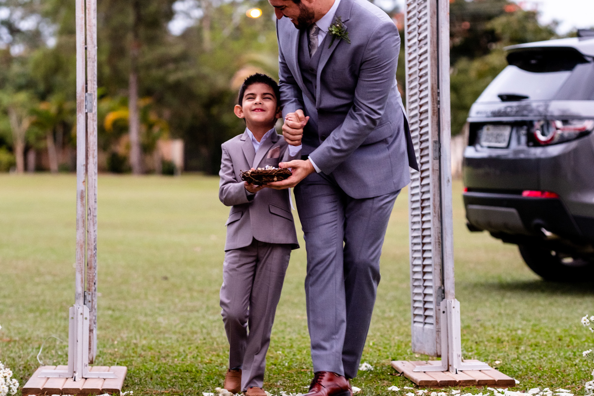 pagem noivo buscando seu filho com vergonha para a entrada linda na celebracao da cerimonia de casamento no destination wedding realizado em guaratingueta so 